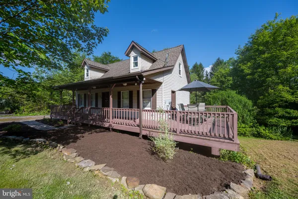 a view of a house with a wooden deck and furniture