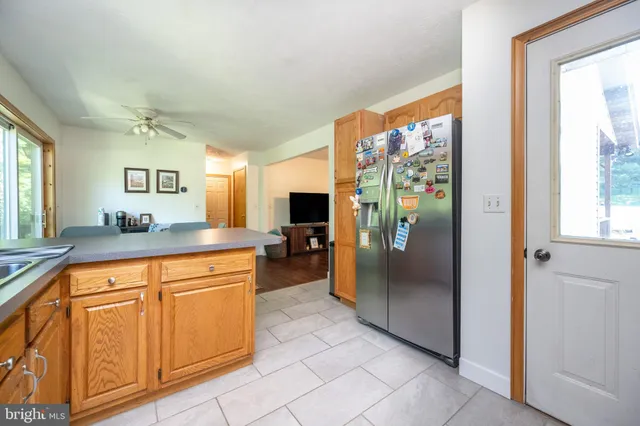 a large kitchen with stainless steel appliances granite countertop a refrigerator and a sink