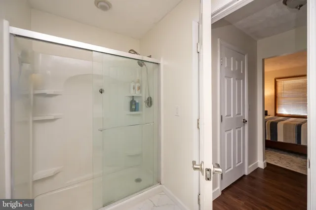 a bathroom with a glass shower door and a sink