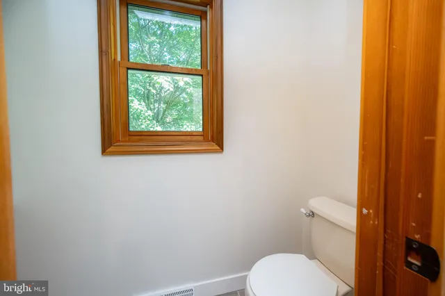 a white toilet sitting next to a window