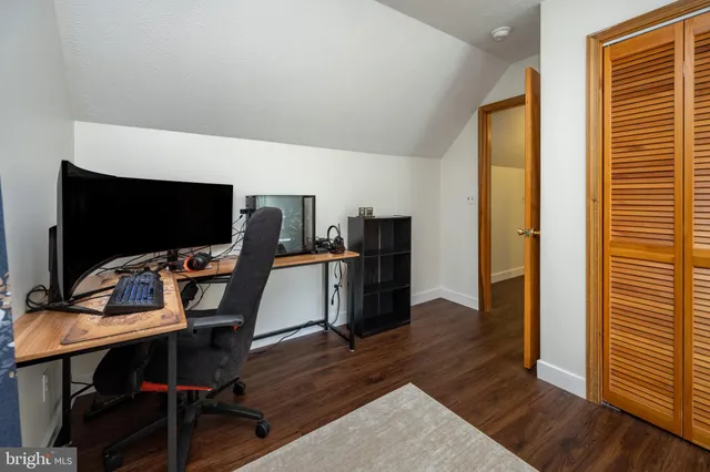 a view of a workspace with furniture and wooden floor