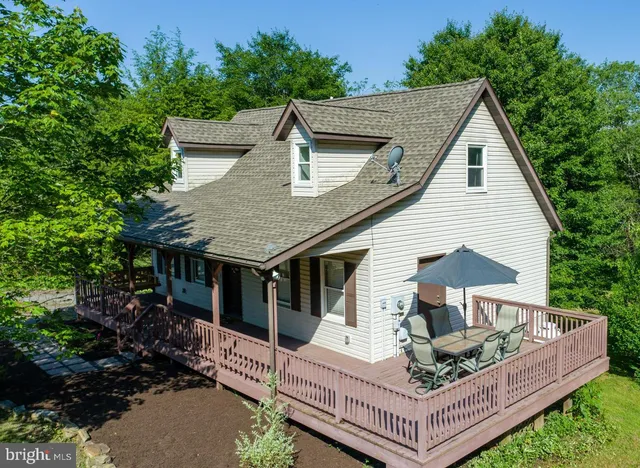 a view of house with backyard and sitting area