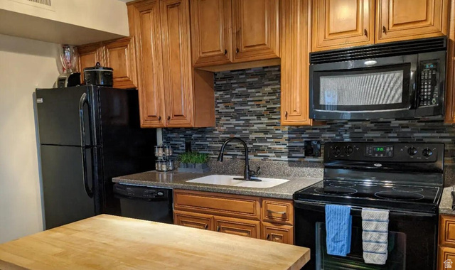 860 Village Road, Unit F7 St. George, UT 84770 - Photo 6 of 18 Kitchen featuring black appliances, wood finish cabinets, and backsplash