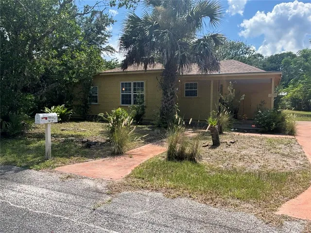 a view of a house with backyard and sitting area