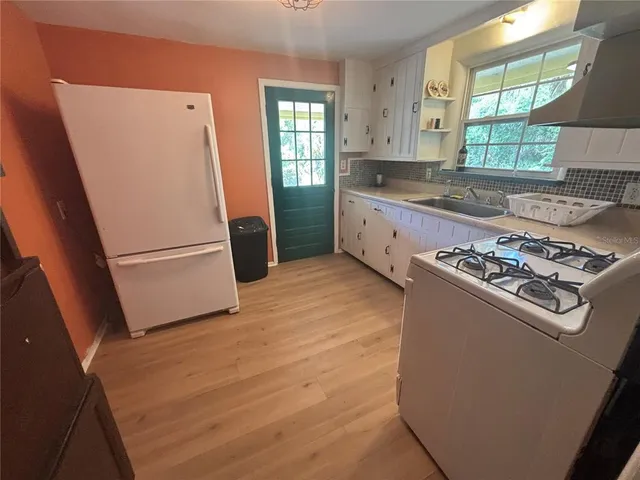 a kitchen with a stove a refrigerator and a window