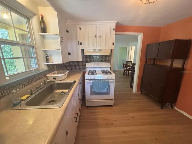 a kitchen with a stove a refrigerator and a sink