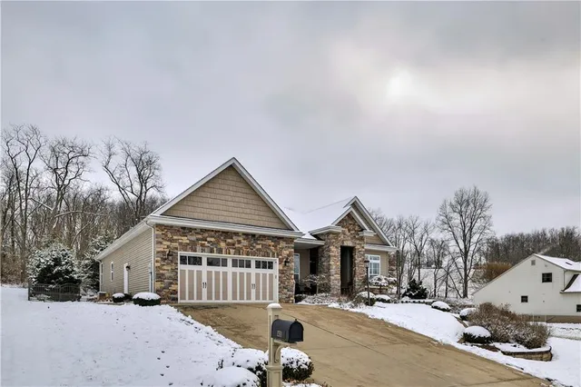 a front view of a house with a yard covered in snow