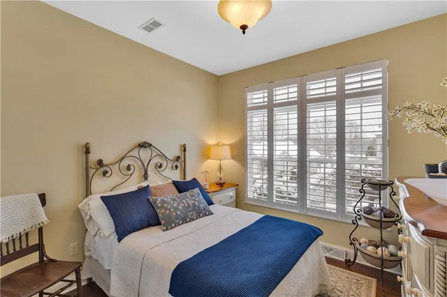 a bedroom with a bed a chandelier and a window