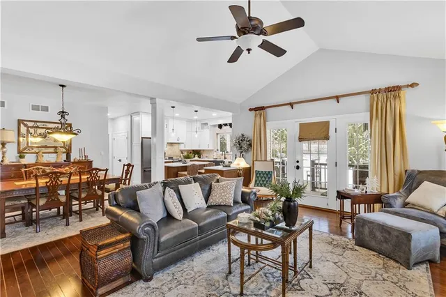 a living room with furniture kitchen view and a window