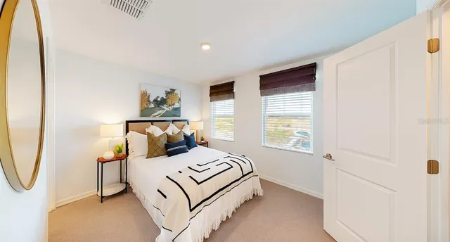 a bedroom with a bed a mirror and a window