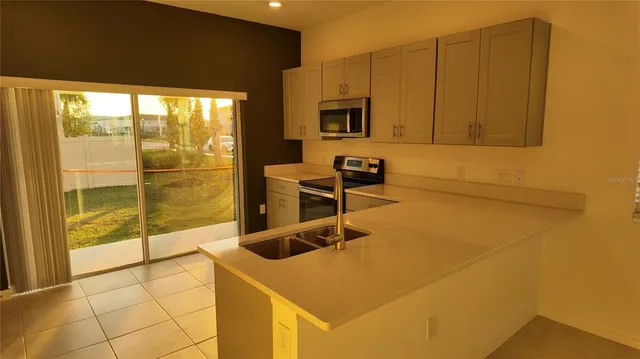 a kitchen with stainless steel appliances a stove a sink and a microwave