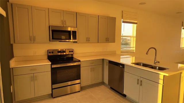 a kitchen with a sink stove and microwave