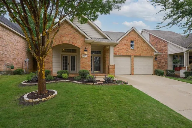 a front view of a house with a yard and trees