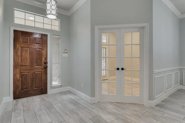 an empty room with wooden floor cabinet and windows