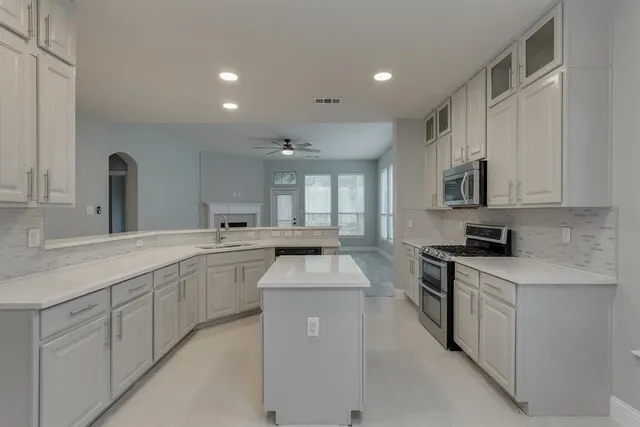 a view of an empty room with a fireplace and a window