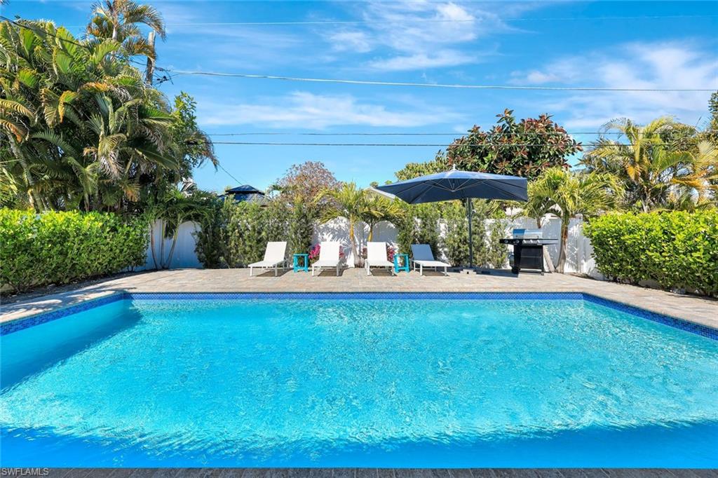 View of pool featuring a fenced backyard, patio surround, and grilling area