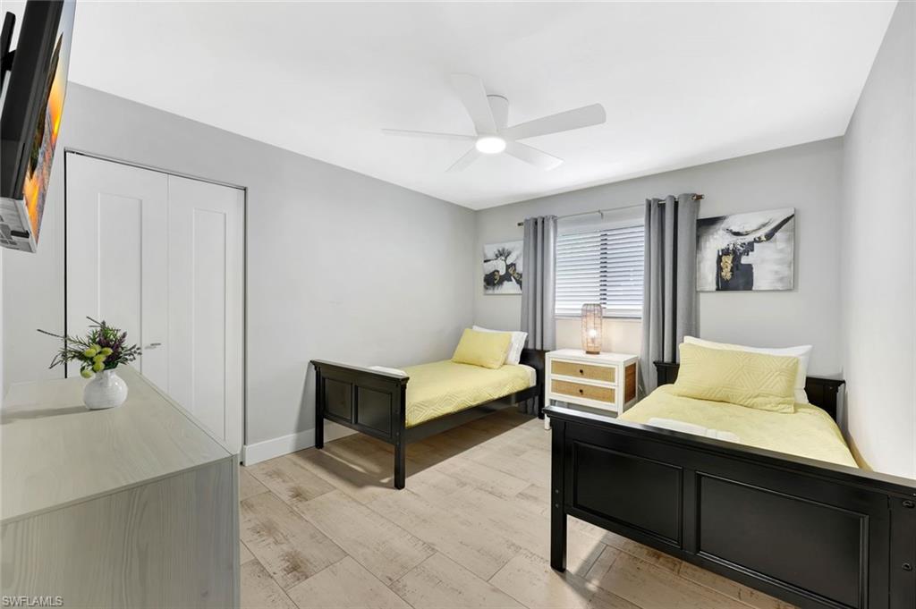 761 99th Avenue North Naples, FL 34108 - Photo 13 of 31 Bedroom featuring a closet, a ceiling fan, and light wood-type flooring