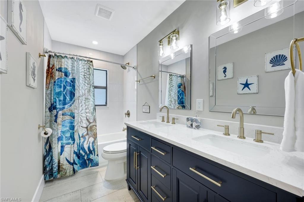 761 99th Avenue North Naples, FL 34108 - Photo 15 of 31 Bathroom with shower / bath combo and double vanity