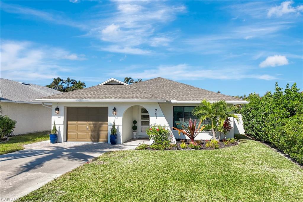 761 99th Avenue North Naples, FL 34108 - Photo 2 of 31 Single story home with a front yard, roof with shingles, stucco siding, and driveway