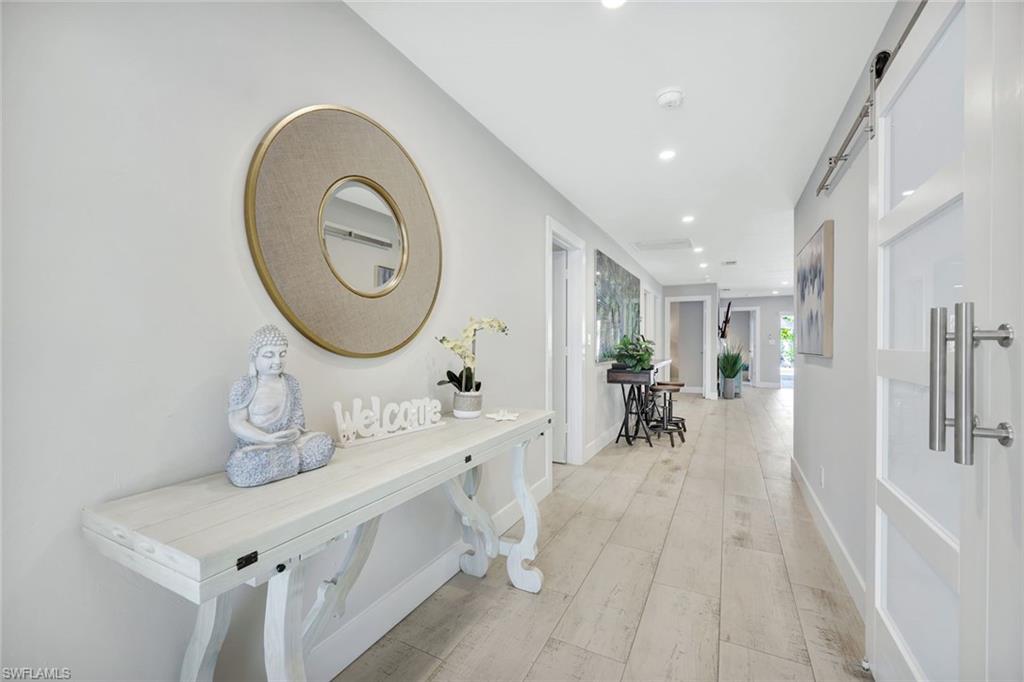 761 99th Avenue North Naples, FL 34108 - Photo 3 of 31 Corridor featuring a barn door, light wood-style flooring, and recessed lighting