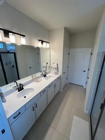 a bathroom with a granite countertop sink a mirror and a shower