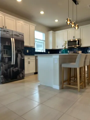 a kitchen with stainless steel appliances granite countertop a stove top oven a sink a counter space and cabinets