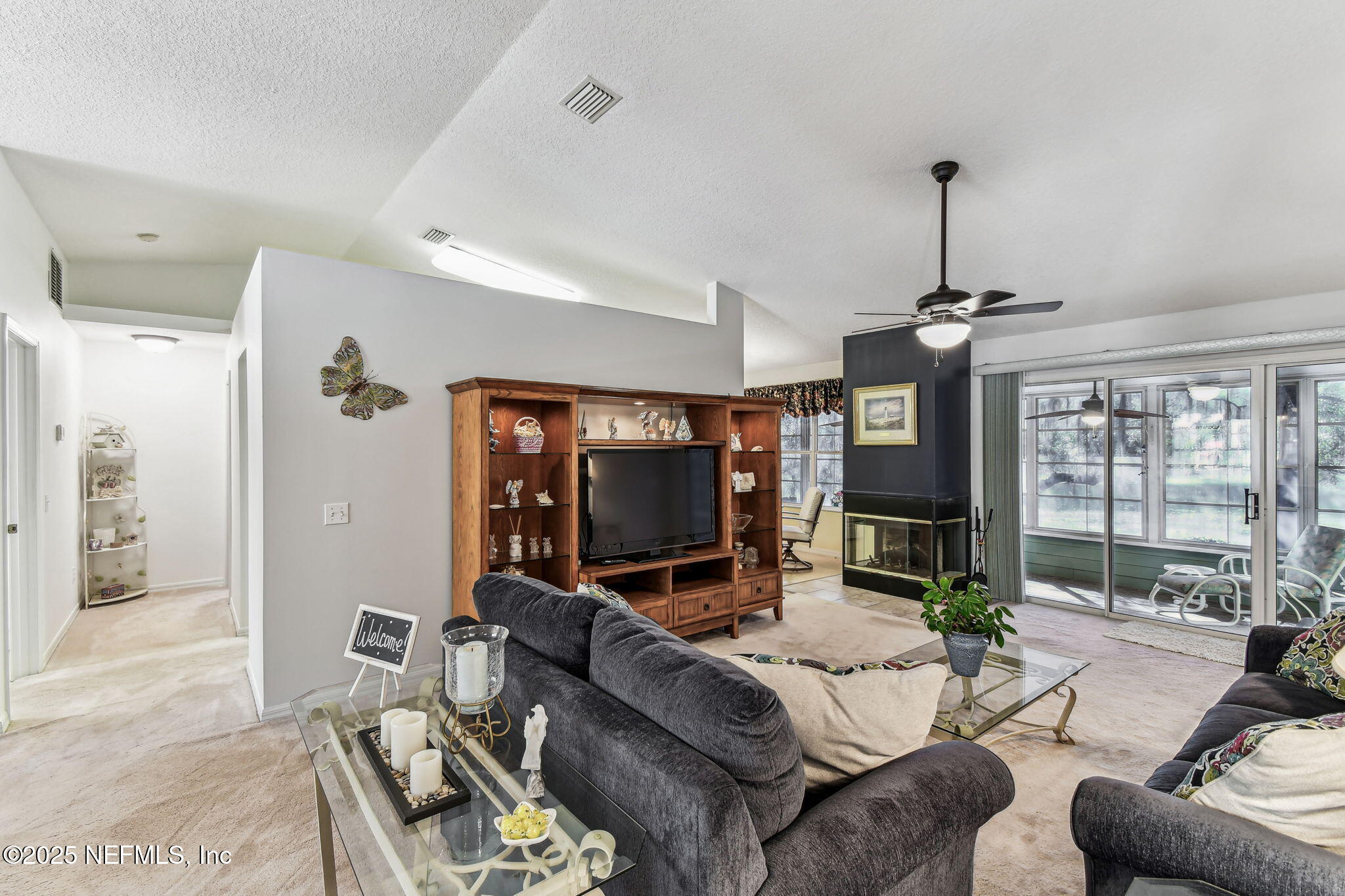 117 Gator Trail Melrose, FL 32666 - Photo 5 of 67 a living room with furniture a flat screen tv and a large window