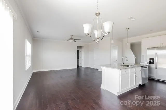 a kitchen with stainless steel appliances a stove refrigerator and cabinets