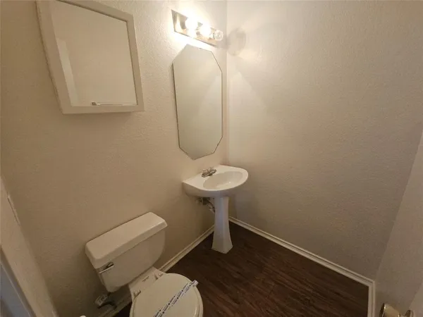 a bathroom with a toilet a sink and mirror