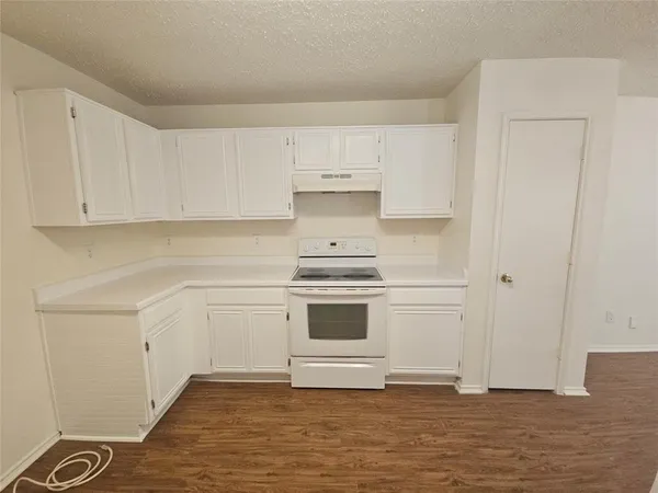 a kitchen with granite countertop white cabinets and white appliances