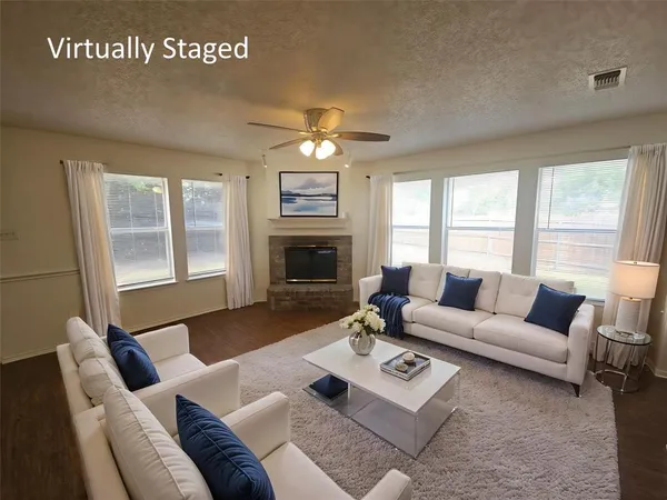 a living room with furniture a fireplace and a large window