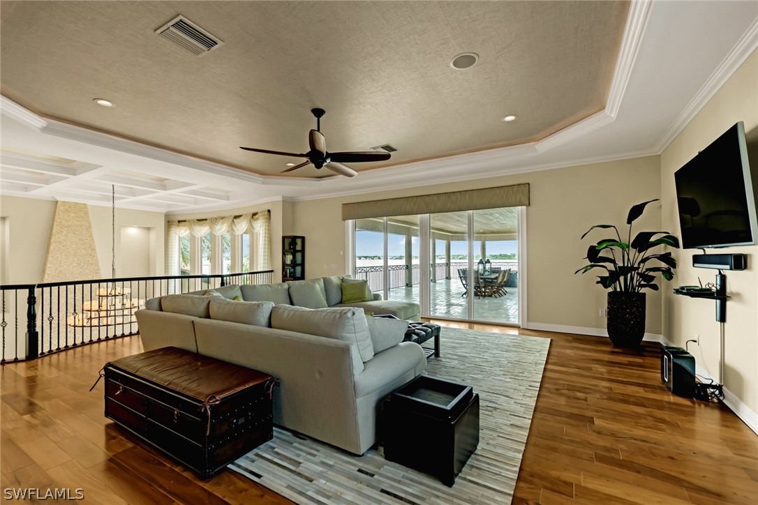 8347 Midnight Pass Road Sarasota, FL 34242 - Photo 11 of 34 a living room with furniture a flat screen tv and a floor to ceiling window