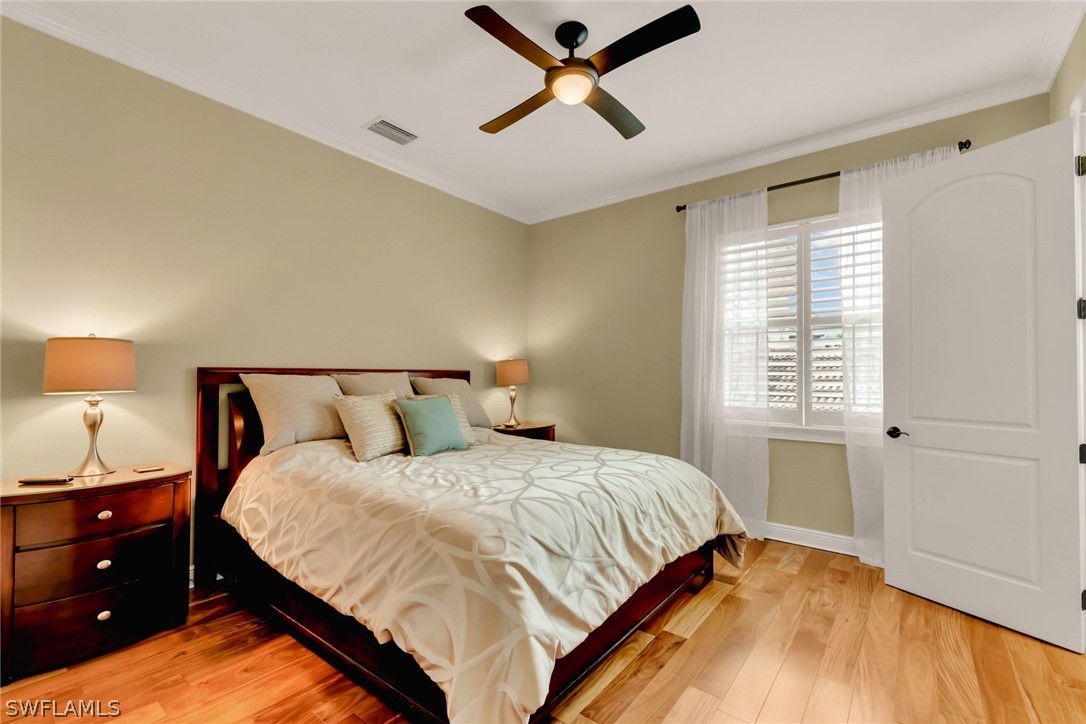 8347 Midnight Pass Road Sarasota, FL 34242 - Photo 19 of 34 a bedroom with a bed and wooden floor