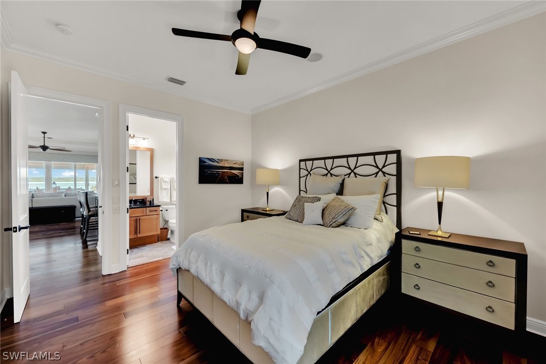 8347 Midnight Pass Road Sarasota, FL 34242 - Photo 2 of 34 a bedroom with a large bed and a chandelier