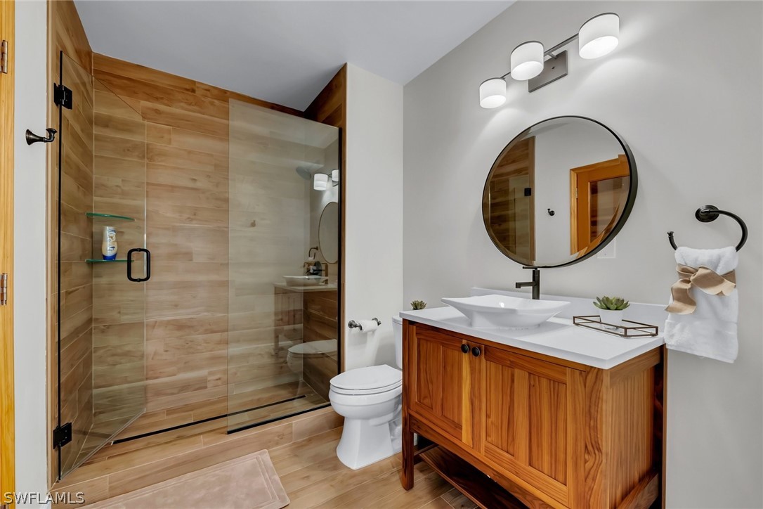 8347 Midnight Pass Road Sarasota, FL 34242 - Photo 26 of 34 a bathroom with a toilet a sink and a mirror