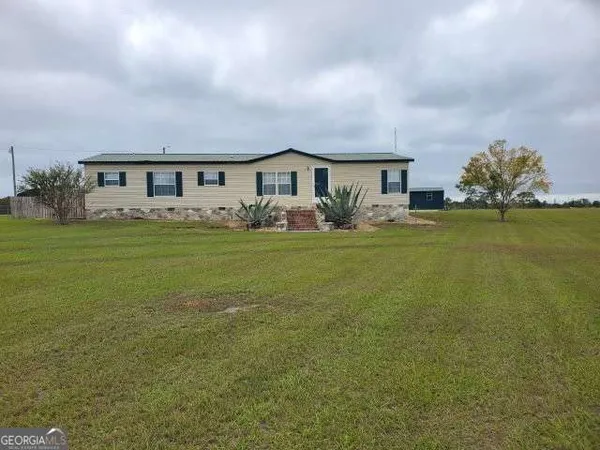 a front view of a house with a garden and yard