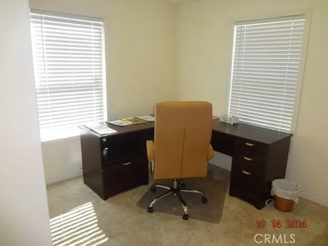 a view of a workspace with furniture and a window