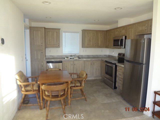 16355 Dam Road Clearlake, CA 95422 - Photo 6 of 21 a kitchen with stainless steel appliances granite countertop a table and chairs in it