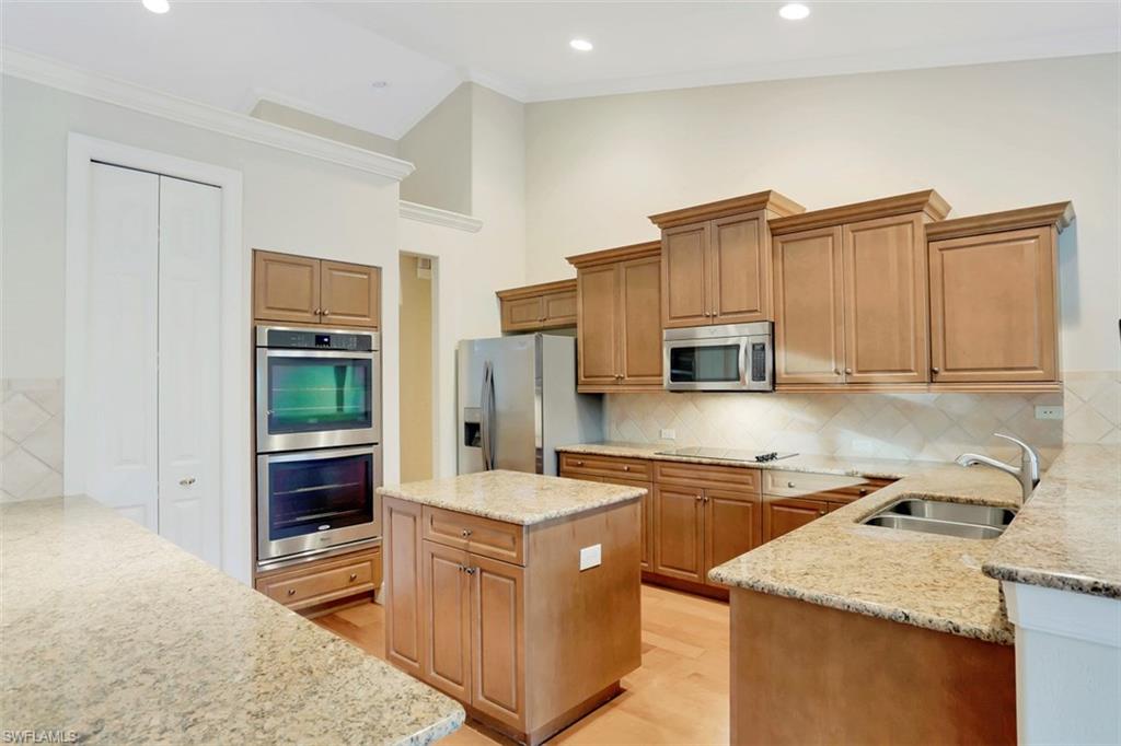 7856 Classics Drive Naples, FL 34113 - Photo 11 of 25 a kitchen with stainless steel appliances granite countertop a sink stove and refrigerator