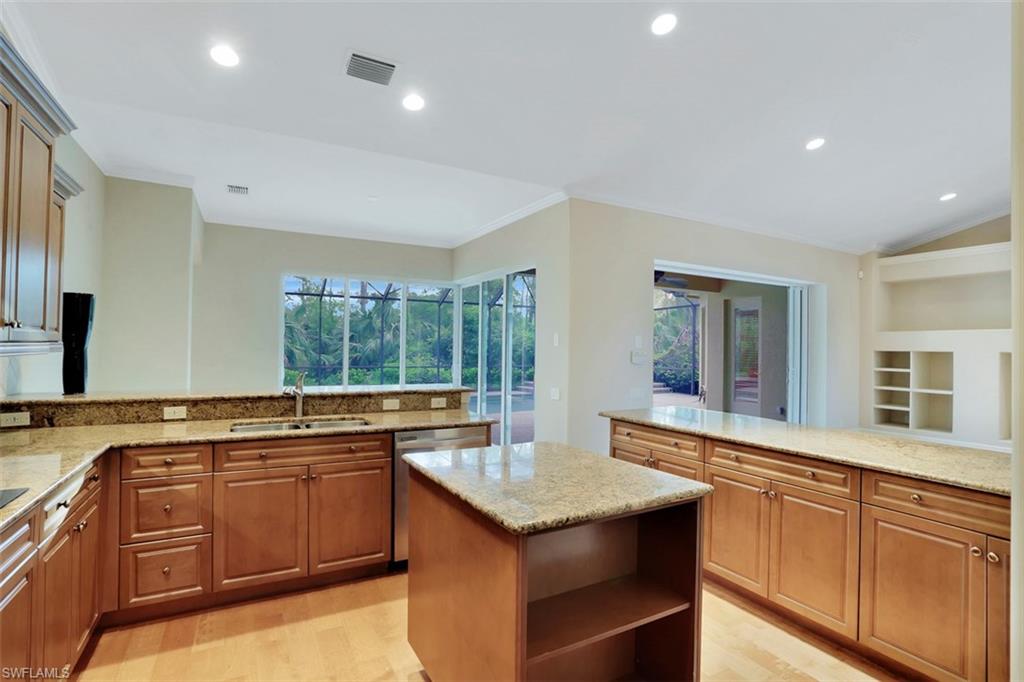 7856 Classics Drive Naples, FL 34113 - Photo 13 of 25 a kitchen with a stove sink and cabinets