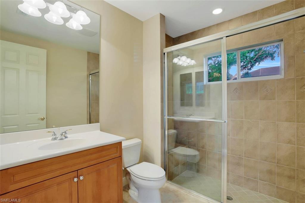 7856 Classics Drive Naples, FL 34113 - Photo 14 of 25 a bathroom with a toilet a sink and mirror