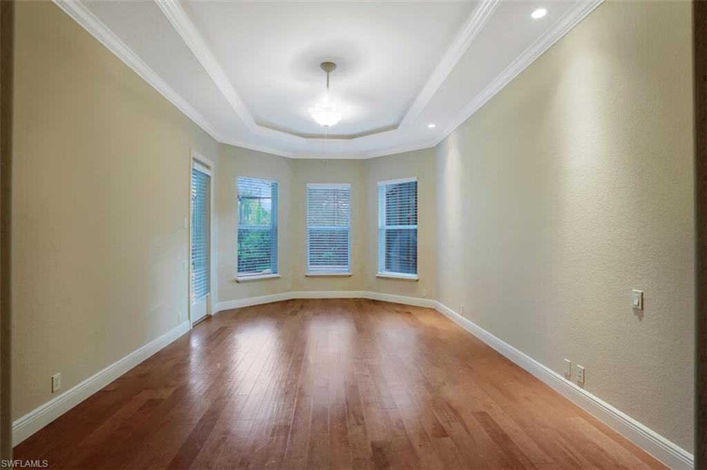 7856 Classics Drive Naples, FL 34113 - Photo 17 of 25 a view of an empty room with wooden floor and a window
