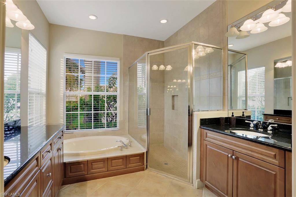 7856 Classics Drive Naples, FL 34113 - Photo 18 of 25 a bathroom with a granite countertop tub sink a mirror a shower and vanity