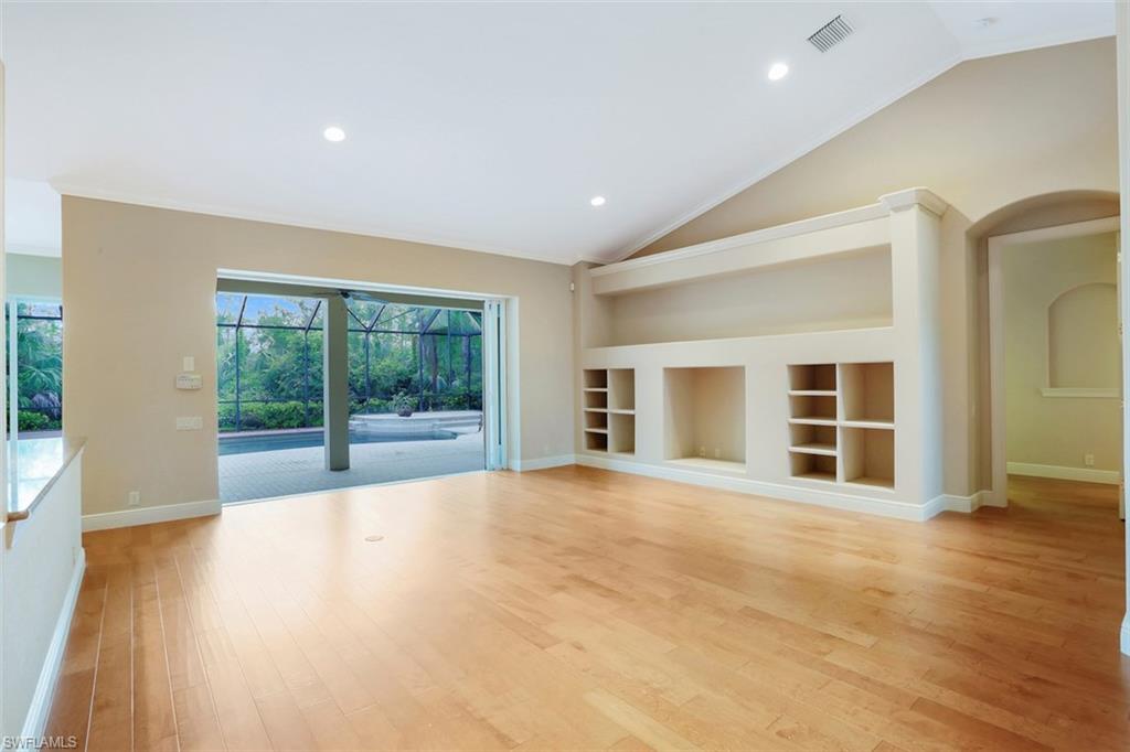 7856 Classics Drive Naples, FL 34113 - Photo 4 of 25 a view of an empty room with wooden floor and a window