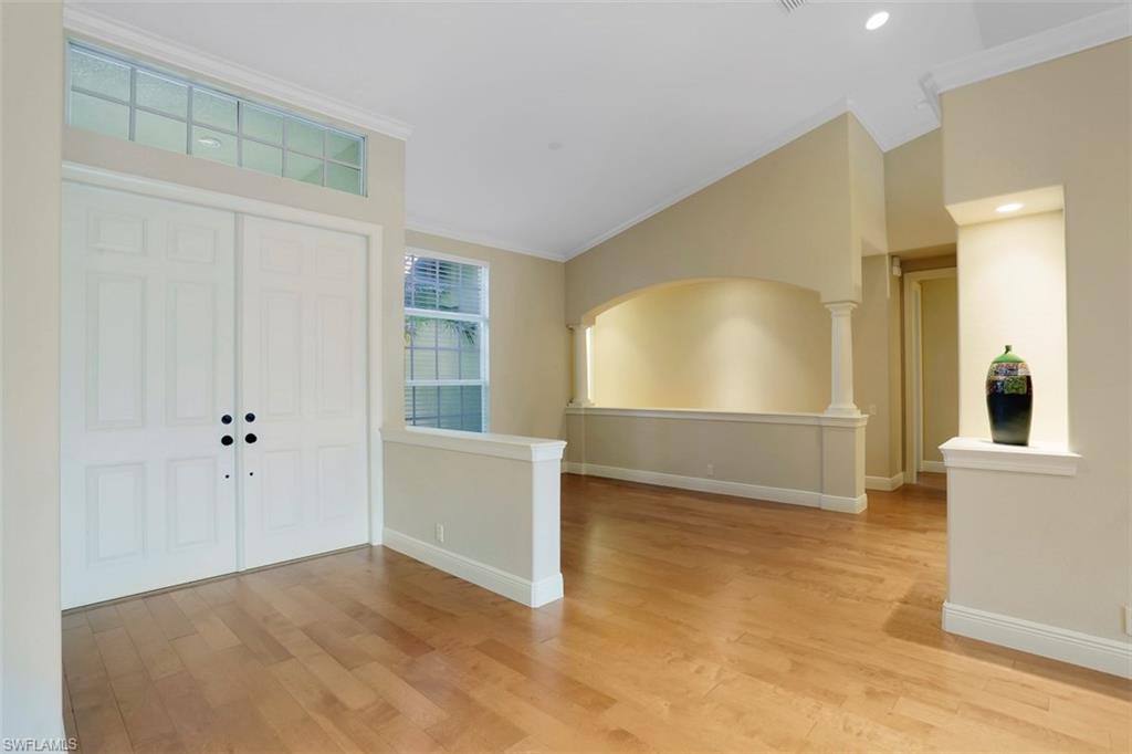 7856 Classics Drive Naples, FL 34113 - Photo 6 of 25 a view of an empty room with window and wooden floor
