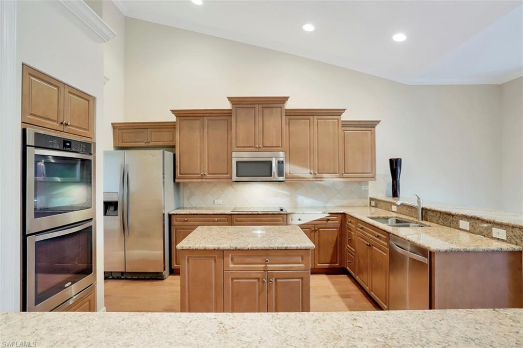 7856 Classics Drive Naples, FL 34113 - Photo 10 of 25 a kitchen with stainless steel appliances granite countertop a sink stove and refrigerator