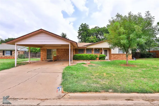 a front view of a house with a yard and trees