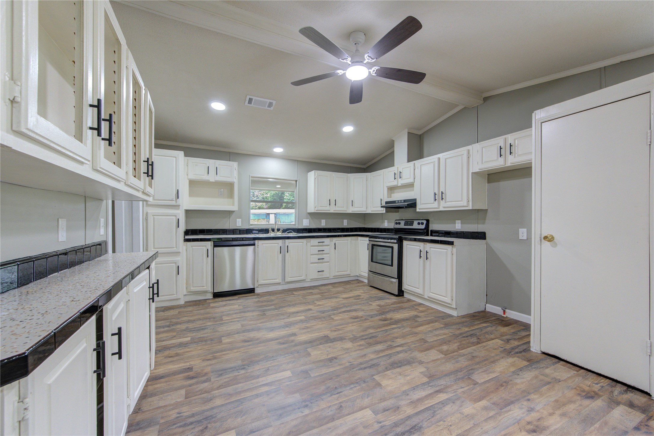 30226 Davis Street Magnolia, TX 77355 - Photo 3 of 50 Spacious kitchen with modern appliances, ample cabinetry, and a ceiling fan. Features include light wood flooring, neutral tones, and plenty of natural light.