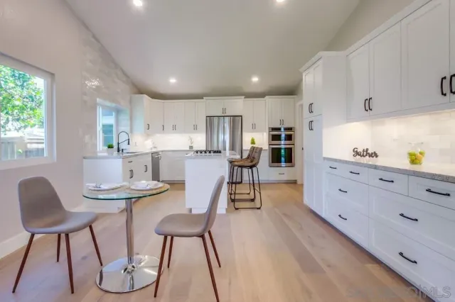 a kitchen with white cabinets and stainless steel appliances