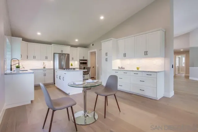 a kitchen with appliances cabinets and chair